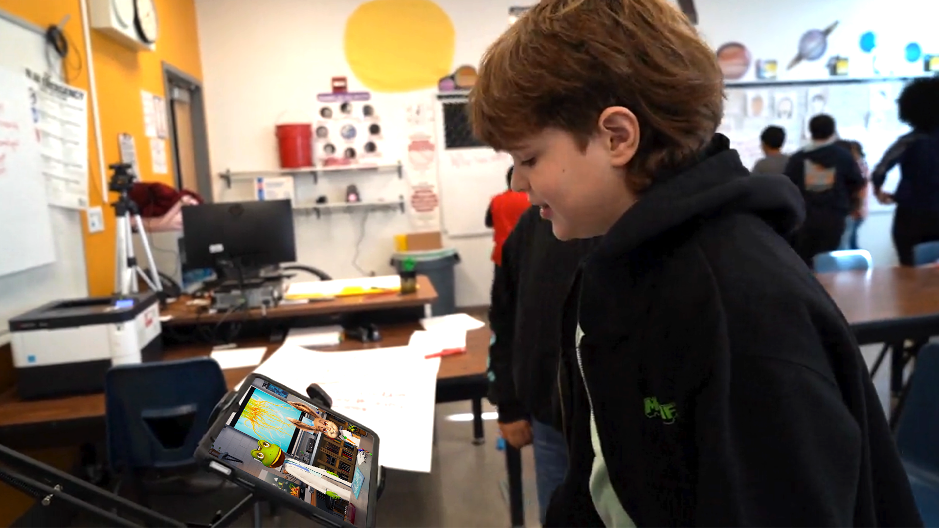 A student talking with interactive characters on a tablet during class