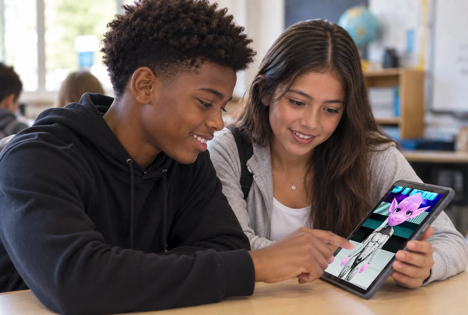 Two students smiling while interacting with a character on a tablet.