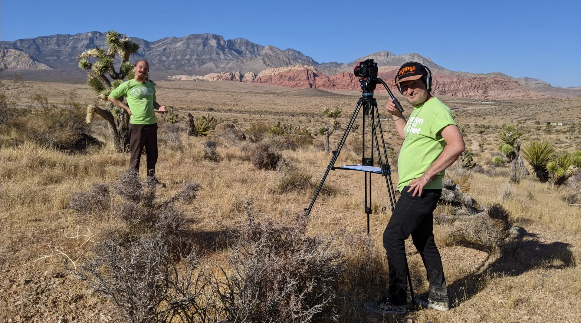 Green Our Planet Studios team filming educational content outdoors among desert mountains and Joshua trees