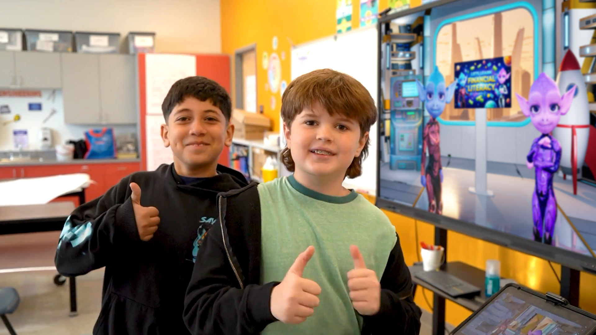 Students smiling and giving thumbs up in a classroom.