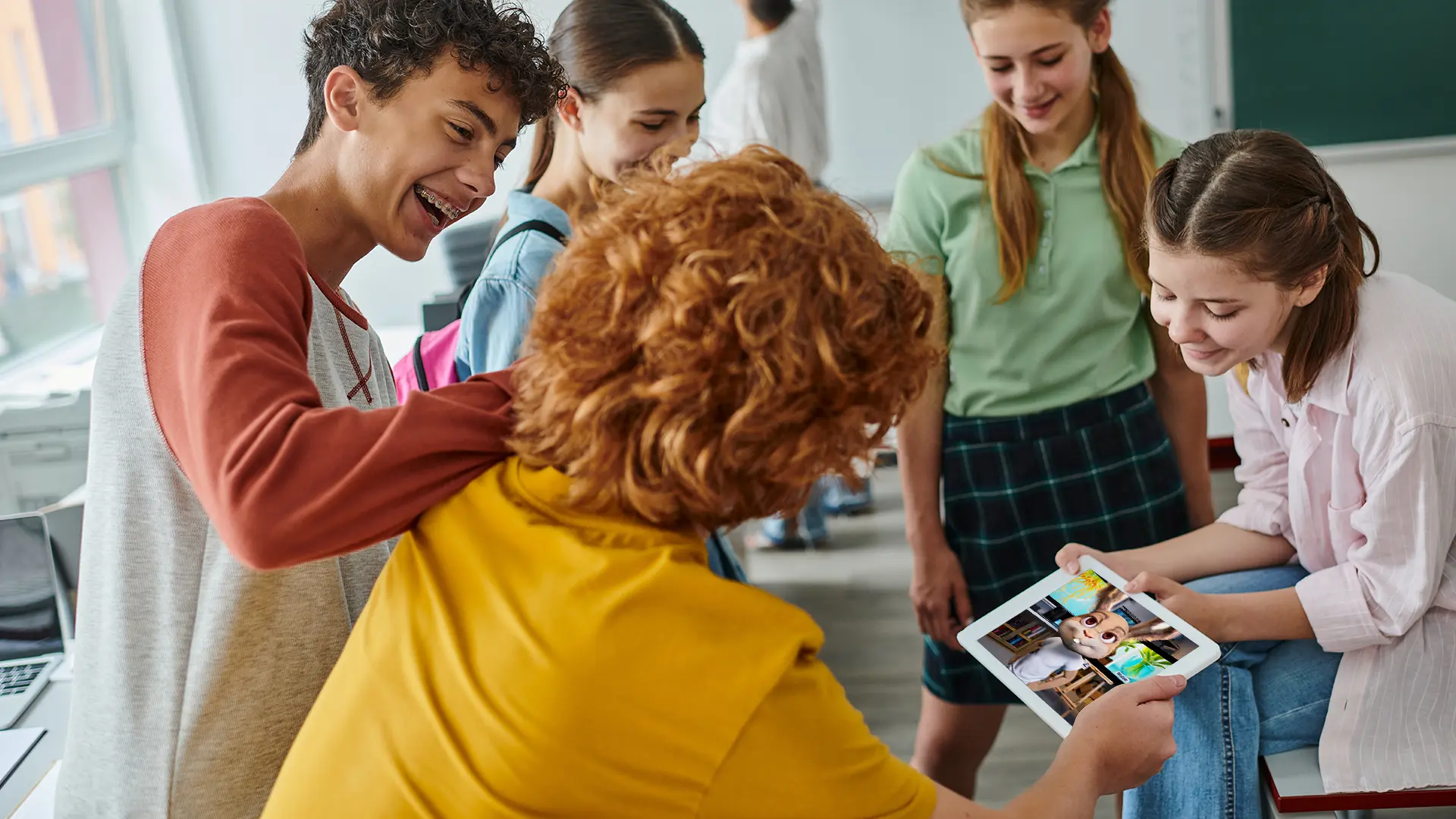 A STEM teacher showing a student an interactive lesson on a classroom iPad.