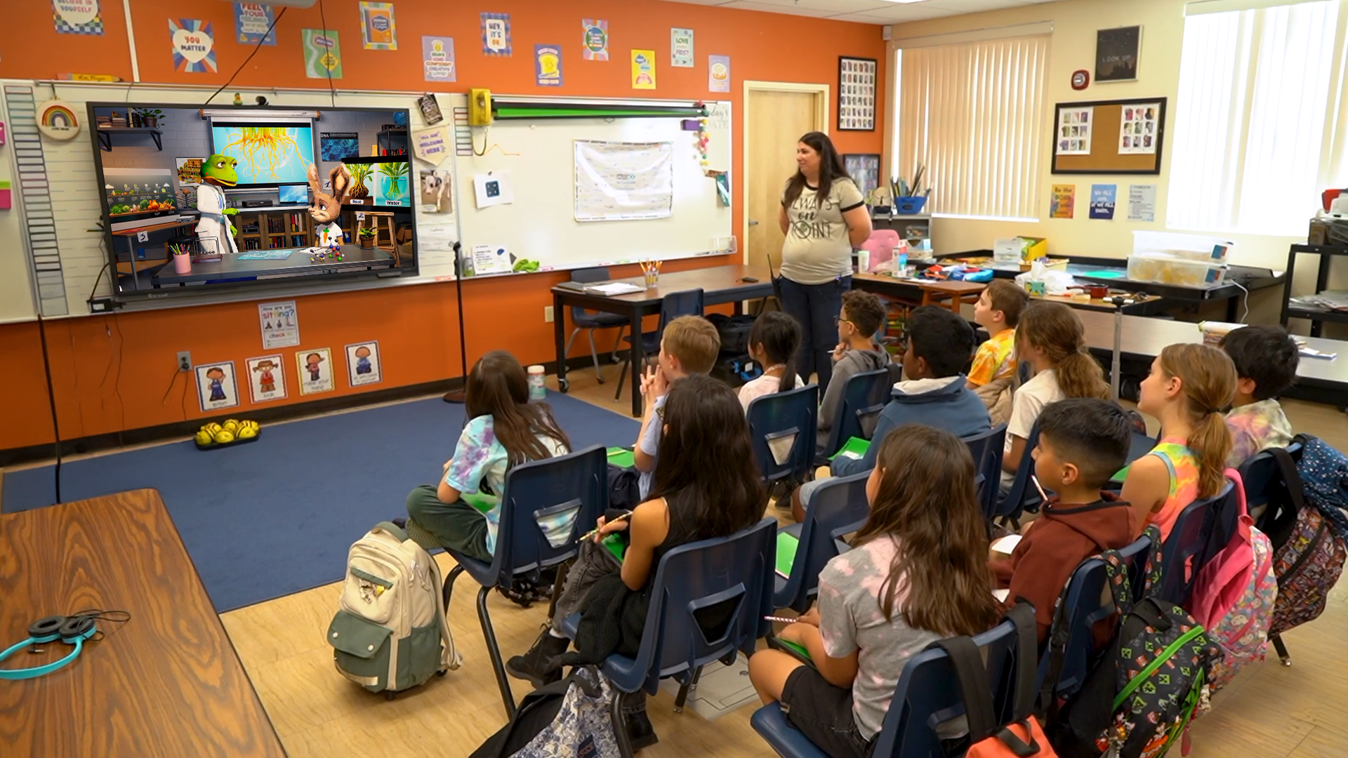 A teacher working alongside a student at a laptop.